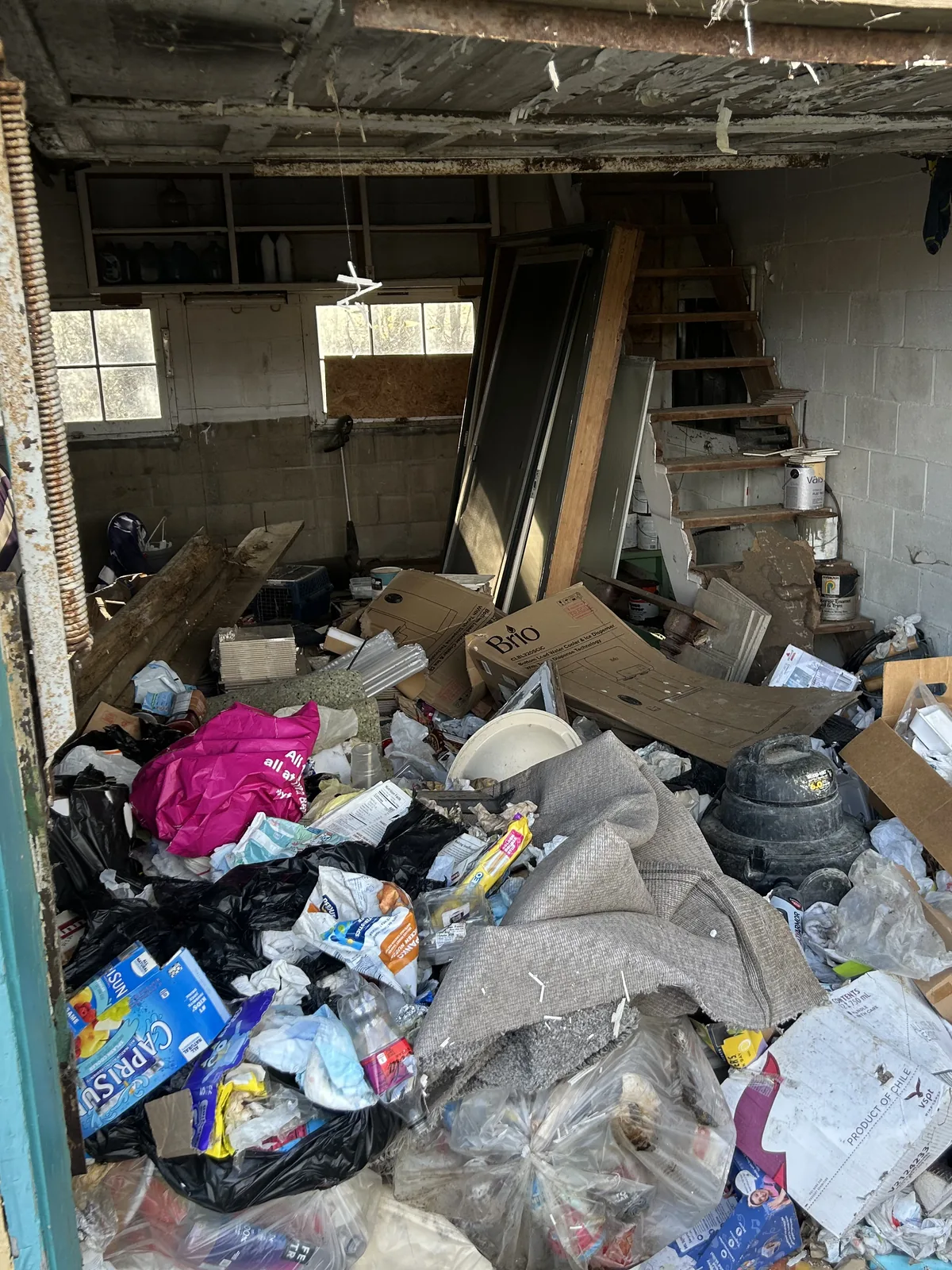 Garage packed wall to wall with household junk before removal